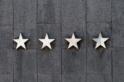 four silver metal stars on a gray wooden background
